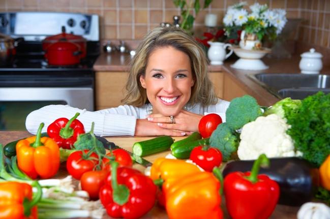 Young smiling woman cooking in the kitchen